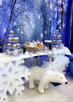 there is a polar bear statue in front of the dessert table