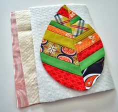 a colorful patchwork piece on top of a white cloth