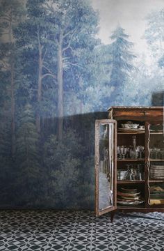 an old wooden cabinet in front of a forest wallpaper