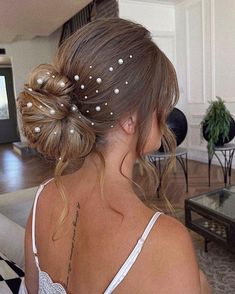 a woman with her hair in a bun and some pearls on it's head