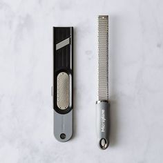 a hair clipper next to an electric razor on a marble surface with the blade removed