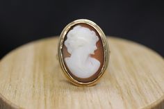 Precious Bezel set Shell cameo ring. Set in 10k yellow gold. Vintage made before middle of century. Marked BDA - Budlong, Dockert & Armstrong Condition: shows signs of wear consistent with old age. Details 3.7grams total weight 10k gold and carved shell 20mm by 15mm rectangle cameo Antique Carved Yellow Gold Jewelry, Gold Round Cameo Signet Ring, Antique Carved Jewelry For Anniversary, Antique Yellow Gold Intaglio Jewelry, Gold Cameo Signet Ring Collectible, Classic Oval Cabochon Collectible Jewelry, Gold Signet Ring With Cameo Collectible, Vintage 14k Gold Carved Jewelry, Vintage Carved 14k Gold Jewelry