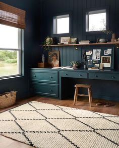 a home office with blue walls and wooden flooring, along with an area rug on the floor