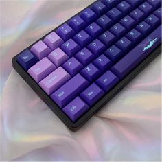 a purple keyboard sitting on top of a white sheet