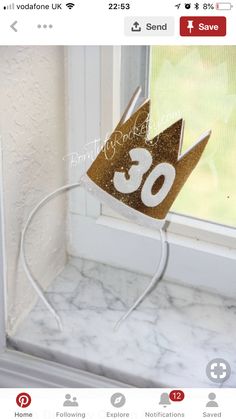 a gold crown sitting on top of a window sill next to a white wall