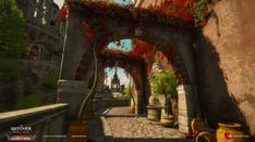 an arch with flowers growing on it is in the middle of a stone walkway between two buildings