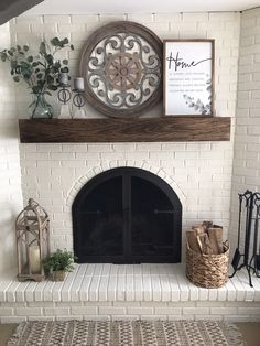 a white brick fireplace with a clock above it and some plants on the mantel