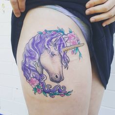 a woman's thigh with a tattoo of a unicorn and flowers on the side