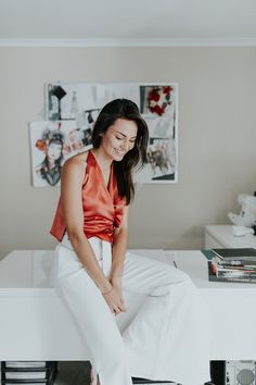 a woman sitting on top of a white table