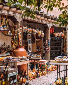 an outdoor market with lots of colorful items on the tables and in front of it