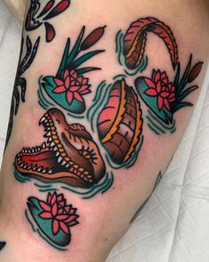 an image of a tattoo on the leg with flowers and snakes coming out of it