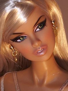 a close up of a barbie doll with blonde hair and big earrings on her head