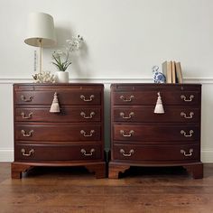 two wooden dressers with tasselled handles on each side and books on top