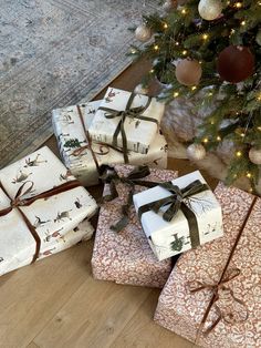 several wrapped presents under a christmas tree on the floor