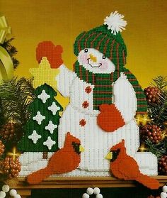 a cross stitch christmas card with a snowman and cardinals