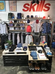 the inside of a store with clothing and hats on display