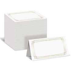 two white cards with gold trims and a blank card in the middle, on top of each other