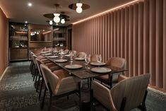 a long dining table with place settings in front of a wall covered with vertical blinds