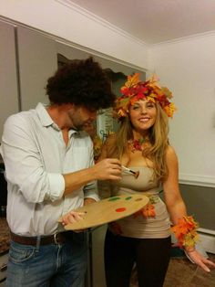 a man standing next to a woman holding a skateboard covered in leaves and flowers