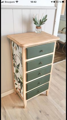 a green and white dresser sitting on top of a hard wood floor next to a wall