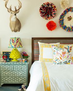 a bed room with a neatly made bed and two deer head mounted on the wall