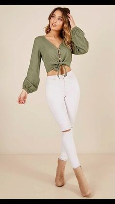 a woman in white jeans and a green top is posing for the camera with her hands on her head