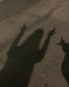 the shadow of two people holding their hands up