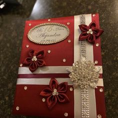 a red and white card with some bows on it's side, sitting on a table