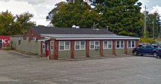 an empty parking lot in front of a building with two cars parked next to it