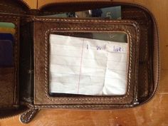 an open wallet sitting on top of a wooden table