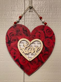 a heart shaped sign with roses hanging from it