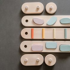 three wooden pegs with different shapes and colors on them sitting next to each other