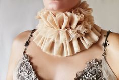 Renaissance Elizabethan high neck ruff collar in warm beige, layered tulle neck collar entirely handcrafted by Elyseeart. Fabric fashion collar. If you want to match a beautiful set of cuffs, see the dedicated section here: https://www.etsy.com/shop/Elyseeart?ref=l2-shop-info-avatar§ion_id=11339802 Please note that colors might be slightly different on your device due to your display settings. ♥ Materials: hand sewn soft comfy warm tulle in beige with adjustable ribbons at the back. Hand sewn and hand tailored layered tulle. Very nice and soft on skin, comfy to wear. It's adjustable with ribbons at the back - see the last picture. One size fits all. Ready to ship! All my designs are one of a kind and completely handmade - a guarantee that you would be exceptional and unique in the whole wo Elegant Detachable Party Collar, Elegant Detachable Collar For Parties, Elegant Fitted Collars For Spring, Clown Collar, Elizabethan Collar, Ruff Collar, Tudor Era, Collar Fashion, Warm Beige