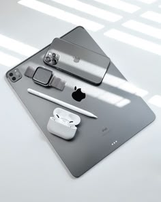 an apple product is displayed on top of a tabletop with other accessories and gadgets