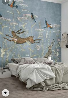 a bed room with a neatly made bed next to a wall mural on the wall