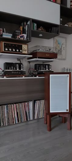 an old record player is sitting in front of a shelf full of cds and records