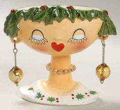 a ceramic figurine with christmas decorations on it's head