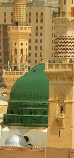 a green dome on top of a building in the middle of a city with tall buildings behind it