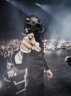 a man in a gas mask pointing at the camera