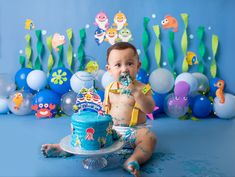 a baby boy sitting in front of a cake with decorations on it and under the water