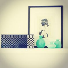 two vases are sitting on a shelf next to a framed photograph