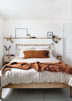 a bed with white sheets and brown pillows