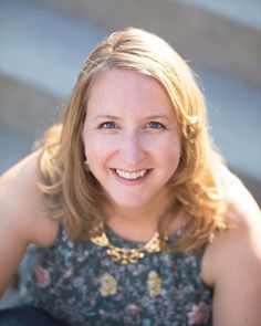 a woman sitting on steps smiling for the camera