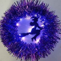 purple tinsel sprinkles are in the shape of a circle with two silhouettes on it