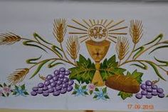 an image of a cross with grapes and bread on it in front of a wall