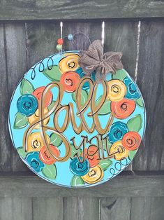 a blue and orange plate with the words love you on it hanging from a wooden fence