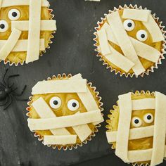 four cupcakes with googly eyes wrapped in paper