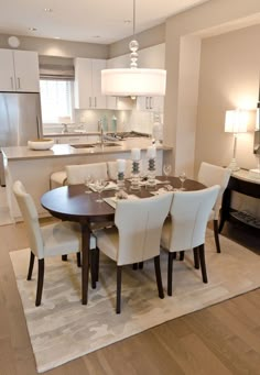 the dining room table is set with white chairs