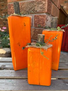 three orange vases sitting on top of a wooden pallet