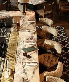 a long table with wine bottles and glasses on it in a restaurant or bar area